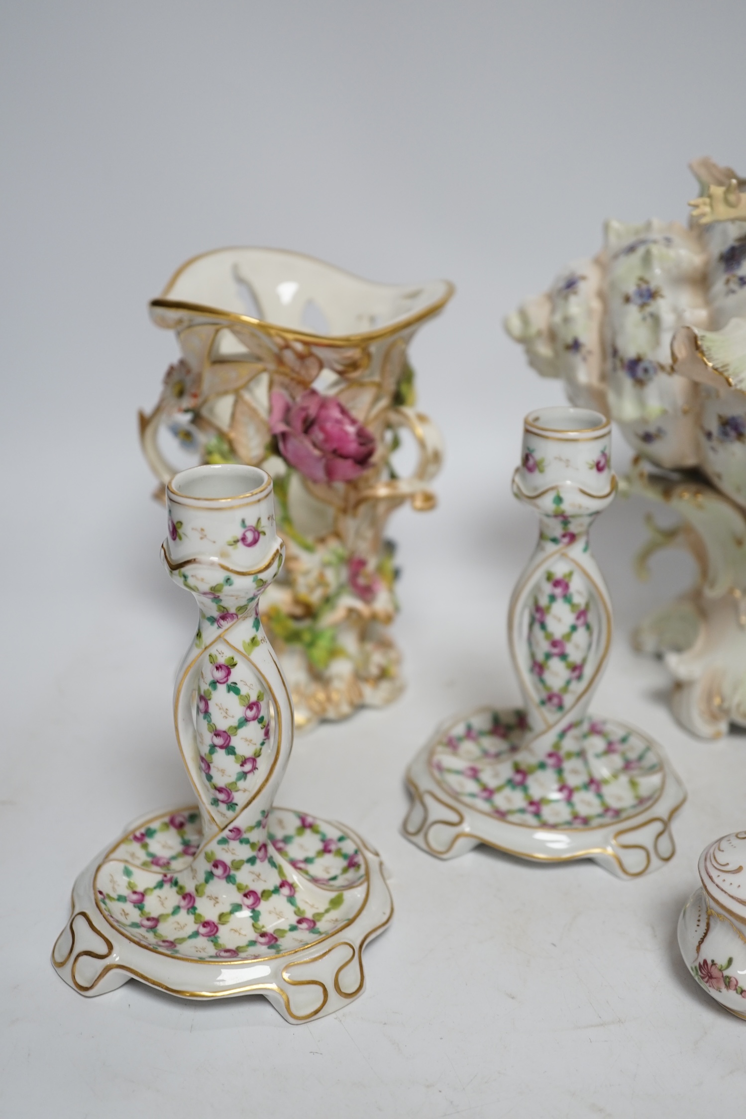 A porcelain shell-shaped centrepiece, a Dresden pill box, a pair of taper holders and a porcelain figure, tallest 21cm